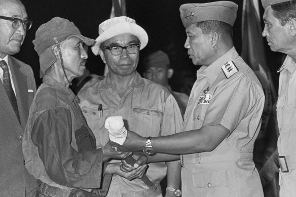 Hiroo Onoda surrenders his sword after emerging from the jungle in March 1974.