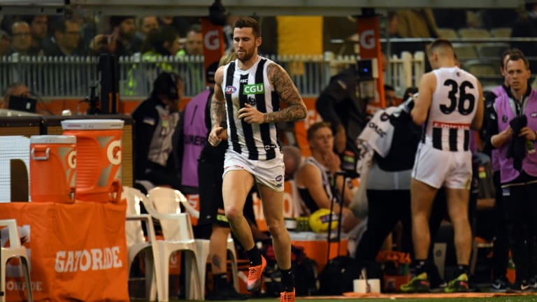 Jeremy Howe of the Magpies (left) is seen after sustaining an injury during the  Preliminary Final. 