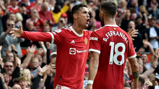 Cristiano Ronaldo celebrates with Portuguese teammate Bruno Fernandes after scoring the opening goal of the English Premier League match between Manchester United and Newcastle United at Old Trafford.