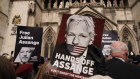 A demonstrator holds a placard calling for the release of Julian Assange outside the Royal Courts of Justice in London in March.