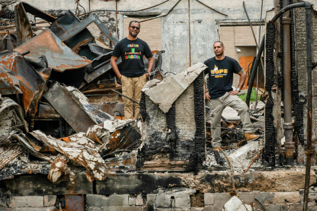 Ruhel Islam in the ruins of his Minneapolis restaurant, Gandhi Mahal, which was destroyed in the riots after George Floyd's death. Pictured here with his manager  and friend, Pastor Riz Prakasim. 