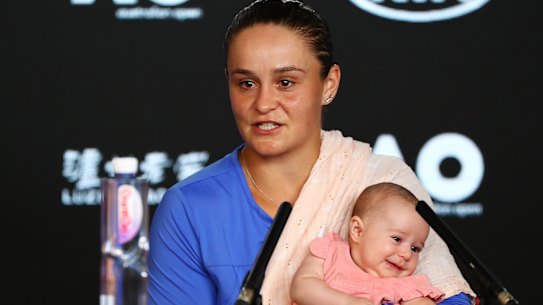 Ashleigh Barty holds niece Olivia while speaking to the media after the match.