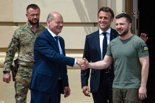 KYIV, UKRAINE - JUNE 16: Ukrainian President Volodymyr Zelensky shakes hands with German Chancellor Olaf Scholz as France's President Emmanuel Macron taps him on the back on June 16, 2022 in Kyiv, Ukraine.  The leaders made their first visits to Ukraine since the country was invaded by Russia on February 24th.