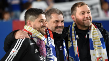 Papas, left, celebrates Yokohama F. Marinos' title win last season with Ange Postecoglou and Peter Cklamovski.