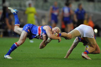 Jason Akermanis tackles Josh Drummond.