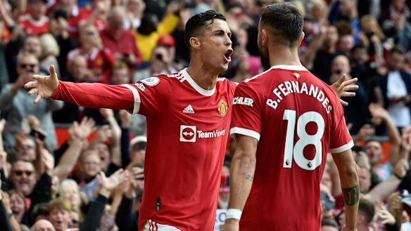 Cristiano Ronaldo celebrates with Portuguese teammate Bruno Fernandes after scoring the opening goal of the English Premier League match between Manchester United and Newcastle United at Old Trafford.