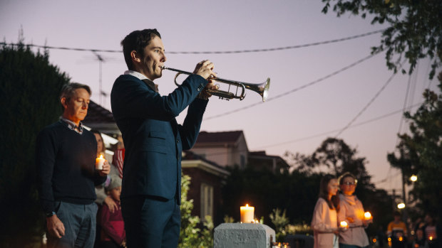 Albie Woodhouse plays The Last Post on trumpet for a driveway dawn service .