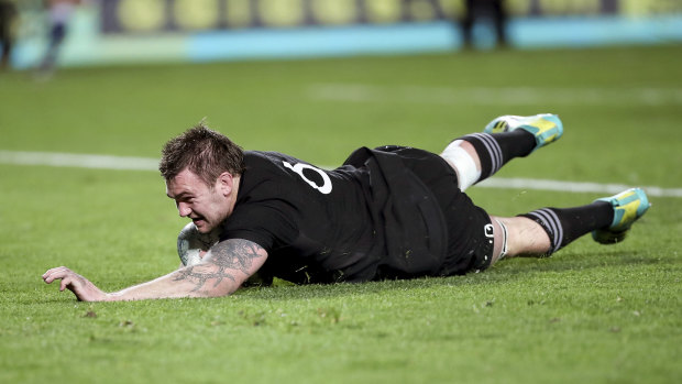 Black tide: Liam Squire crosses the stripe as the All Blacks ratchet up the pressure.