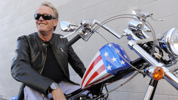 Peter Fonda, poses atop a Harley-Davidson motorcycle in 2009.