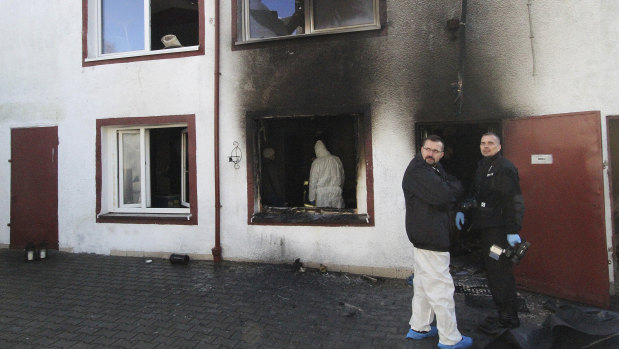 Forensic and police experts examine the site of a fire in an escape room in Koszalin, Poland.