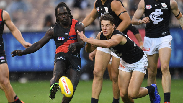 Tipping point: Anthony McDonald-Tipungwuti kicks on despite pressure from Carlton's Liam Stoker.