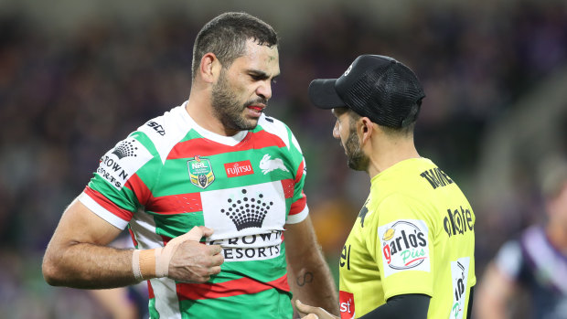 That's the spot: Greg Inglis discusses his rib cartilage injury with a trainer on Friday night.
