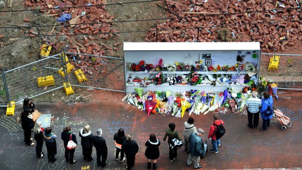 People pay tribute to the three victims at the site of the Swanston Street wall collapse in April 2013.
