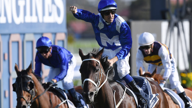 Jockey Hugh Bowman on Winx gestures to the crowd after winning the Queen Elizabeth Stakes.