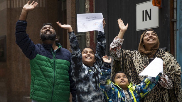 Maruf Ahmed and Sabrina Abbasi and their children wave to Maruf's parents in quarantine at the Raddison Blu.