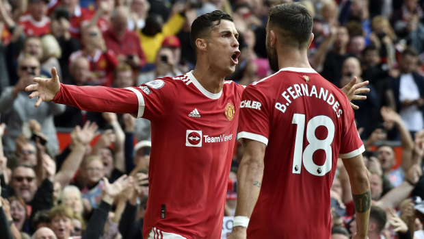 Cristiano Ronaldo celebrates with Portuguese teammate Bruno Fernandes after scoring the opening goal of the English Premier League match between Manchester United and Newcastle United at Old Trafford.