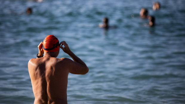 A man prepares to take to the water at Coogee Beach on Saturday morning.