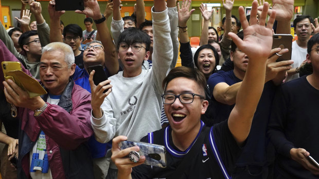 A big night for democracy in Hong Kong. Supporters of pro-democracy candidate Angus Wong celebrate after he won in district council elections.