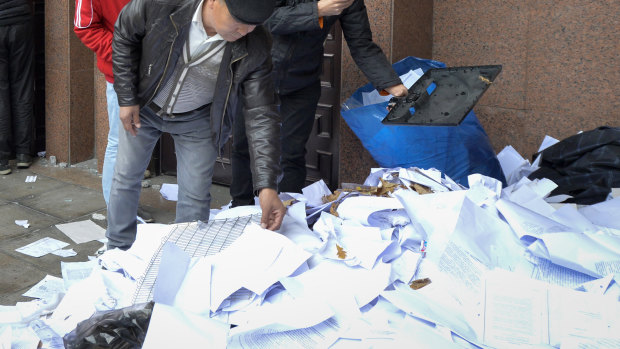 Protesters look through documents removed from government headquarters during protests on Tuesday.