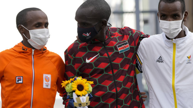 Gold medallist Eliud Kipchoge, of Kenya, centre, stands with silver medallist Abdi Nageeye, of the Netherlands, left, and bronze medallist Bashir Abdi of Belgium after the race.