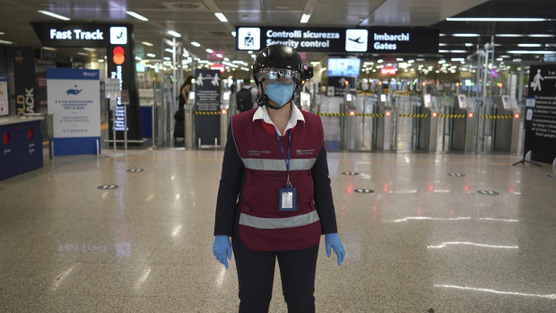 A woman wears a "smart helmet" scanner, which measures the body temperature of passengers for possible coronavirus symptoms, at Rome's Leonardo da Vinci international airport.