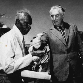 Gurindji leader Mr Vincent Lingiari receives a symbolic handful of soil from Gough Whitlam at a ceremony at Daguragu on August 16, 1975.