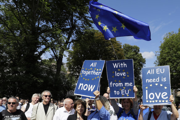 Anti-Brexit demonstrators join Beatles fans, with signs of Beatles songs, to walk across Abbey Road last week.