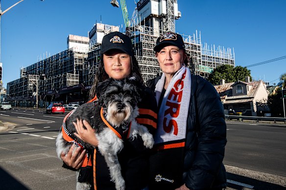 Wests Tigers supporters Ruby Thoroughgood, Joanne Dover and their dog Turbo across the road from the Rozelle Village construction.
