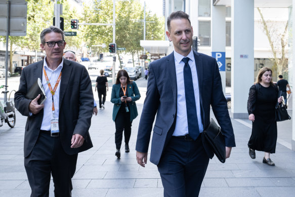Sydney Trains chief executive Matt Longland and Transport for NSW secretary Josh Murray walk into the hearing on Monday to hear the unions present a counter-offer.
