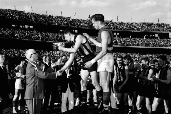 Hawthorn captain, Graham Arthur, is presented with the 1961 Premiership Cup.