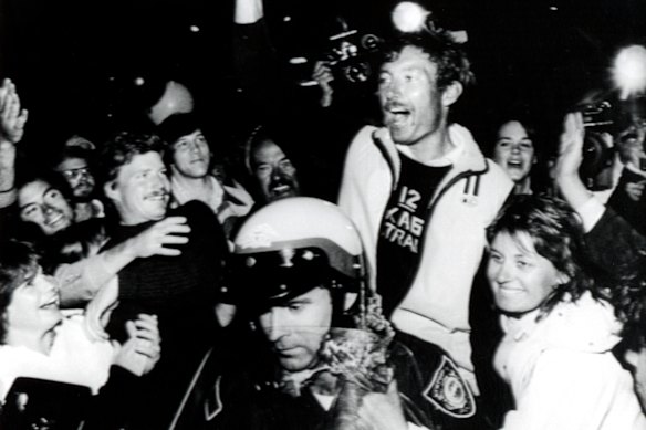 A police officer escorts Australia II skipper John Bertrand through the streets of Newport in 1983.
