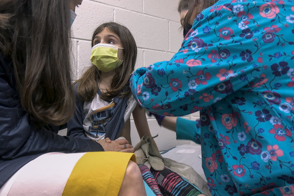 Alejandra Gerardo, 9, looks up to her mother, Dr Susanna Naggie, as she gets the first of two Pfizer COVID-19 vaccinations during a clinical trial for children at Duke Health in North Carolina.