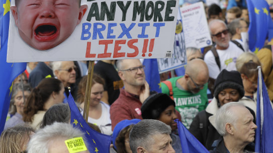 Anti-Brexit demonstrators carry placards and EU flags in London, Saturday