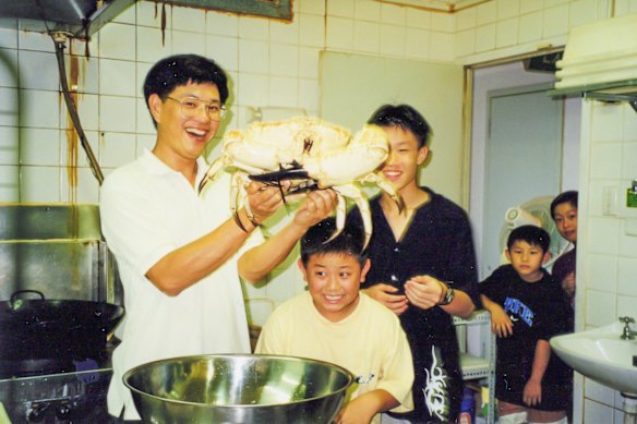 Richard Gan (second from right) and his siblings watch Richard’s uncle handling a Tasmanian king crab, Foo Wah, 2000.
