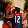ALICE SPRINGS, AUSTRALIA - JULY 17: (L-R) Kysaiah Pickett, James Harmes and Toby Bedford of the Demons celebrate during the 2022 AFL Round 18 match between the Melbourne Demons and the Port Adelaide Power at TIO Traeger Park on July 17, 2022 in Alice Springs, Australia. (Photo by Michael Willson/AFL Photos via Getty Images)