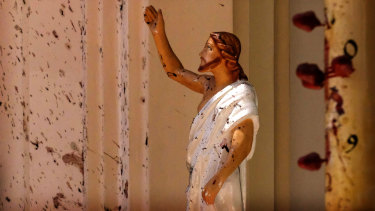 Blood stains the wall and a statue of Jesus Christ after a blast ripped through St Sebastian's Church in Negombo, north of Colombo, on Sunday.