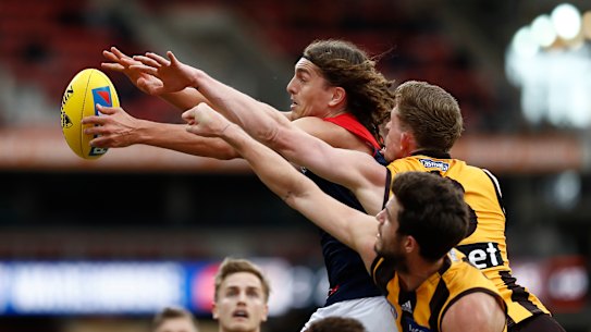 Pole position: Melbourne's Luke Jackson fends off a pair of Hawks.