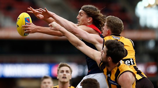 Melbourne's Luke Jackson fends off a pair of Hawks.
