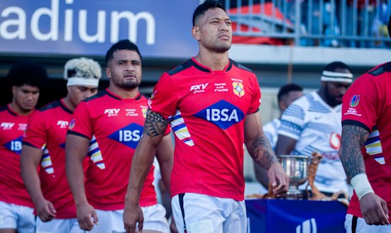 Israel Folau leads out the Tongan rugby team against Fiji in Suva in 2022.