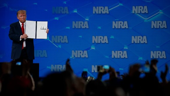 US President Donald Trump holds up a letter to the Senate about the UN Arms Trade Treaty as he speaks to the annual meeting of the National Rifle Association. 