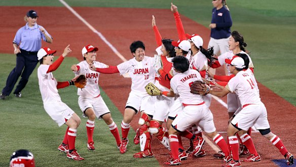 Yukiko Ueno is swarmed by teammates after the final out to defeat the US 2-0 in the softball gold medal game in Yokohama.