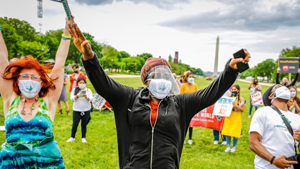 Supporters cheer after it’s announced that the United States will support the waiver at the Rally for Vaccine Access for Everyone, Everywhere in Washington, DC. 