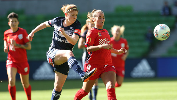 Putting the boot in: Annabel Martin of Melbourne Victory (left) kicks clear from Fanndis Frioriksdottir of Adelaide United during the round one W-League match at AAMI Park in Melbourne.