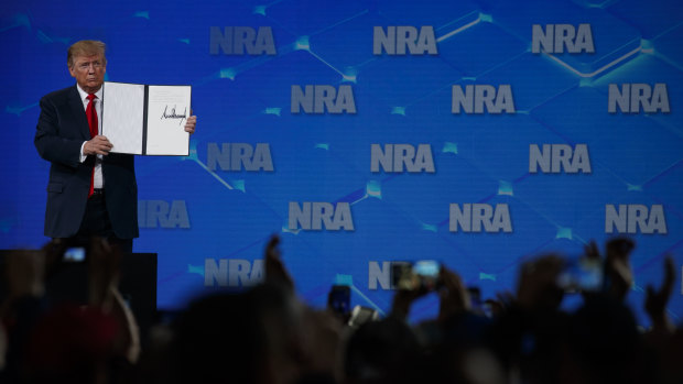 US President Donald Trump holds up a letter to the Senate about the UN Arms Trade Treaty as he speaks to the annual meeting of the National Rifle Association. 