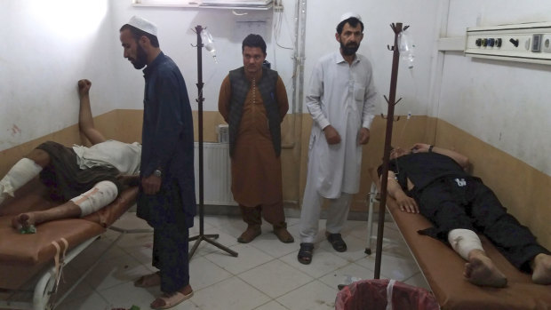 Injured men receive treatment following a deadly bombing at a mosque in Khost on Sunday.