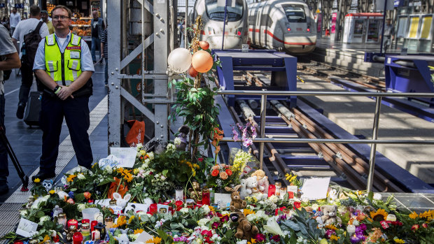 Flowers and candles were placed near a track at the main train station in Frankfurt, Germany.