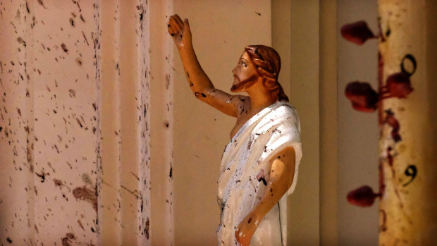 Blood stains the wall and a statue of Jesus Christ after a blast ripped through St Sebastian's Church in Negombo, north of Colombo, on Sunday.