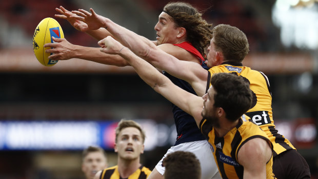 Melbourne's Luke Jackson fends off a pair of Hawks.