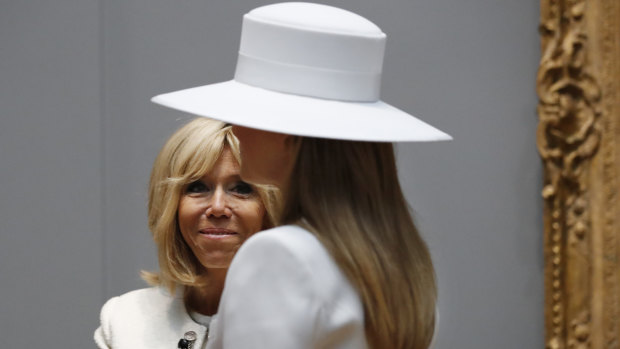French First Lady Brigitte Macron, left, smiles at her counterpart Melania Trump as they tour the National Gallery of Art, in Washington.
