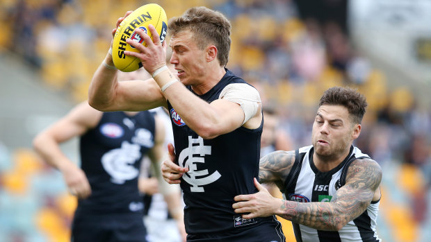 Caught short: Carlton's Patrick Cripps tries to evade a tackle from Collingwood's Jamie Elliott.